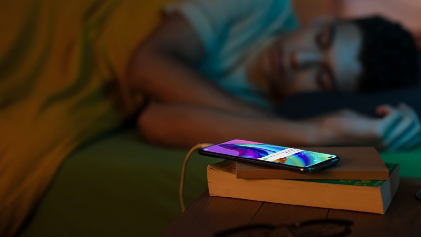 man sleeping while his phone is charging